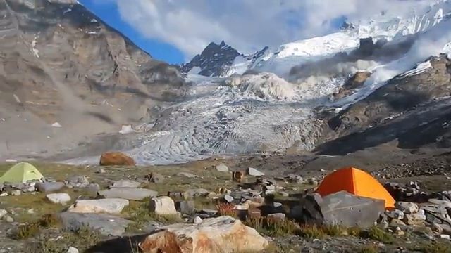 Une avalanche massive de neige fonce droit sur un campement de tentes en montagne