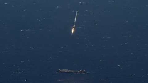 Vue aérienne d'une fusée SpaceX atterrissant verticalement sur une plateforme en mer.