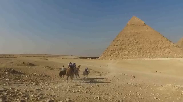 Vue panoramique des pyramides de Gizeh, soulignant les structures monumentales dont la construction reste un sujet de débat.