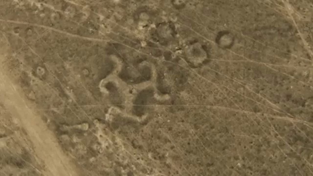 Vue aérienne des géoglyphes du Kazakhstan, montrant des formes géométriques complexes formées par des monticules de terre.