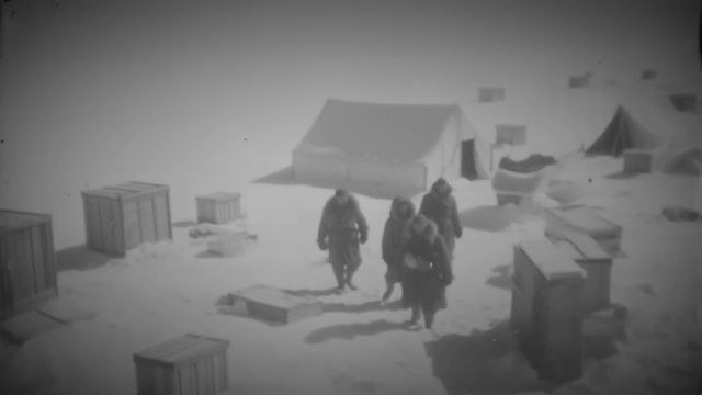 Vue aérienne d'un campement rudimentaire sur la glace, soulignant la logistique complexe nécessaire pour opérer en Antarctique.