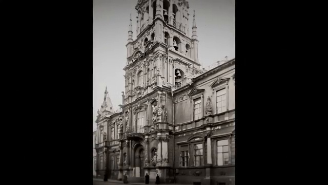 Gros plan sur l'architecture complexe d'une tour avec des sculptures et des cloches intégrées.