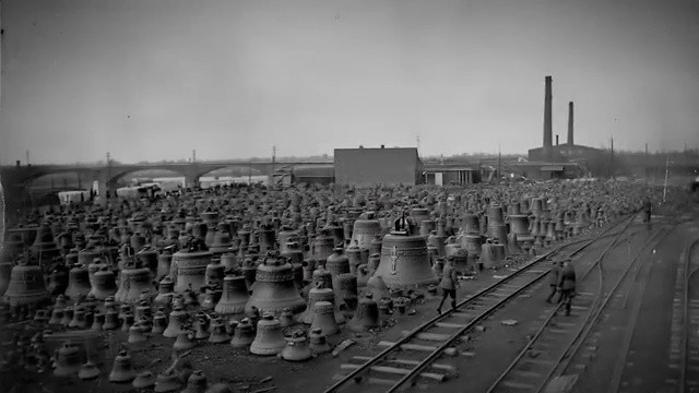 Vue panoramique d'un immense stock de cloches anciennes alignées en plein air.