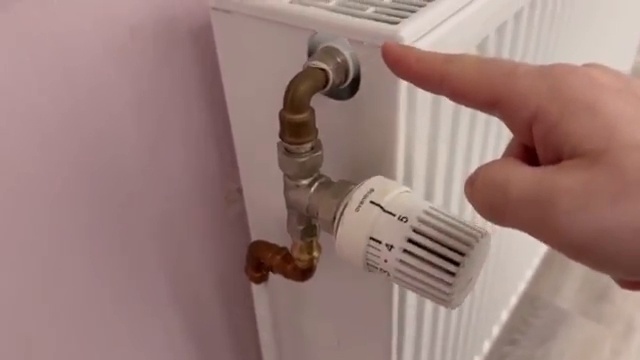 Doigt pointant vers la connexion métallique de la vanne laissant entrer l'eau dans le radiateur