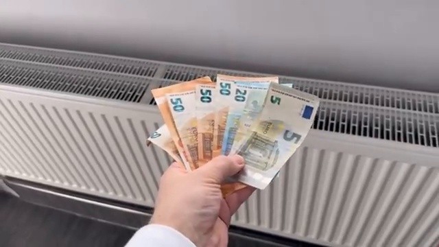 Billets de banque posés sur le radiateur pour illustrer le gaspillage d'argent