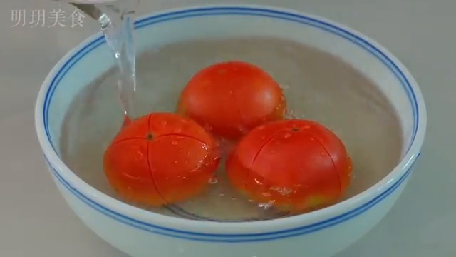 Tomates incisées trempant dans l'eau bouillante pour les peler